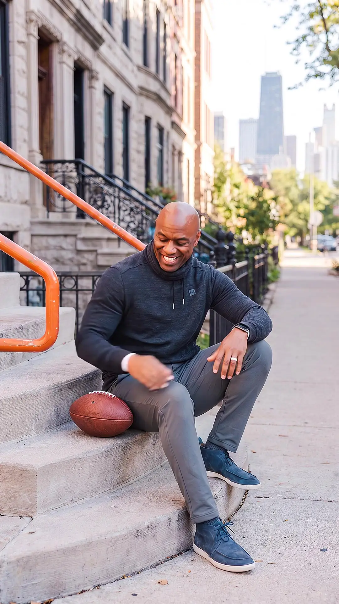 Jarrett Payton on a Chicago greystone stoop with a football beside him